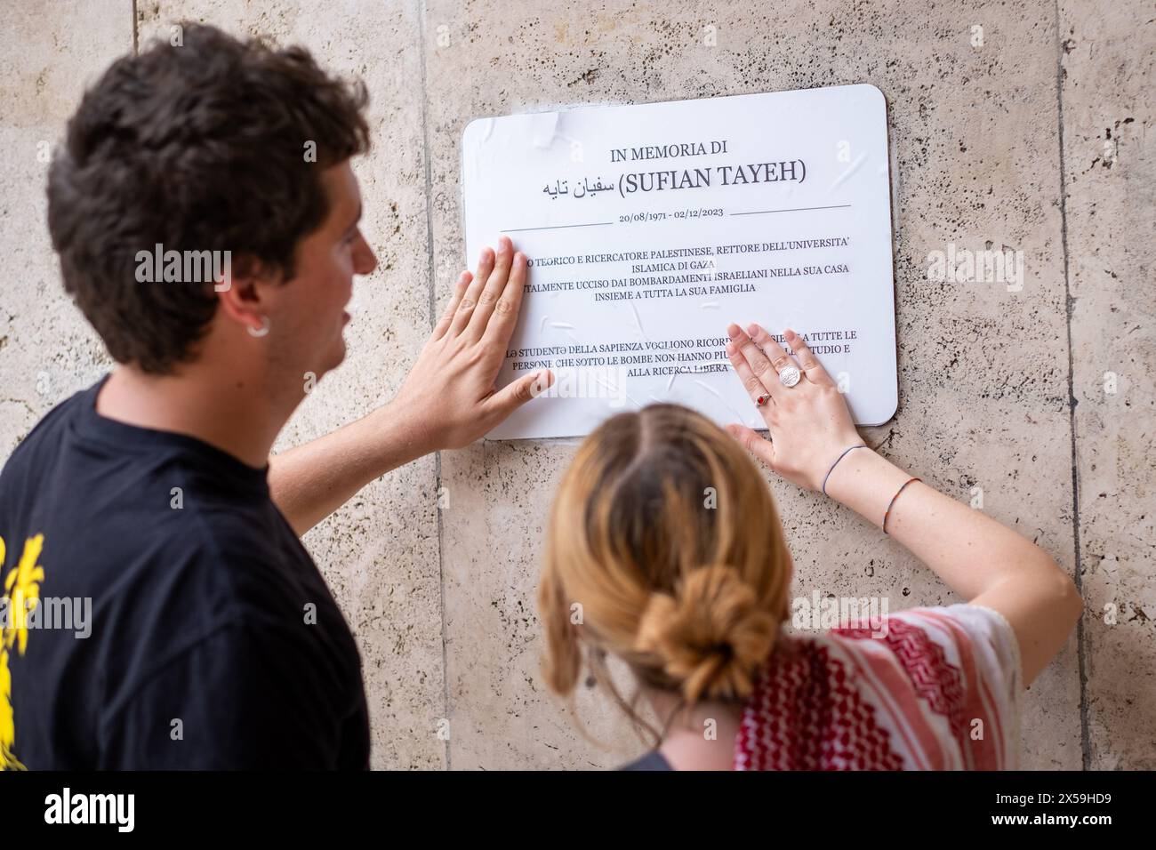 Roma, RM, Italia. 8 maggio 2024. Studenti e professori si riuniscono di fronte alla targa commemorativa, collocata la scorsa settimana all'ingresso della Facoltà di fisica, per ricordare Sufian Tayeh (fisico palestinese, rettore dell'Università di Gaza, ucciso lo scorso dicembre durante il bombardamento di Gaza). La targa è stata vandalizzata ieri da un gruppo di persone mascherate. "Israele" e le stelle di Davide sono state dipinte anche sul muro. Due studenti sostituiscono la placca con una copia cartacea temporanea dell'originale. (Credit Image: © Marco di Gianvito/ZUMA Press Wire) SOLO PER USO EDITORIALE! Non per USO commerciale! Foto Stock