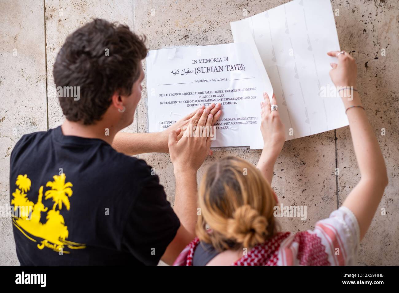 Roma, RM, Italia. 8 maggio 2024. Studenti e professori si riuniscono di fronte alla targa commemorativa, collocata la scorsa settimana all'ingresso della Facoltà di fisica, per ricordare Sufian Tayeh (fisico palestinese, rettore dell'Università di Gaza, ucciso lo scorso dicembre durante il bombardamento di Gaza). La targa è stata vandalizzata ieri da un gruppo di persone mascherate. "Israele" e le stelle di Davide sono state dipinte anche sul muro. Due studenti sostituiscono la placca con una copia cartacea temporanea dell'originale. (Credit Image: © Marco di Gianvito/ZUMA Press Wire) SOLO PER USO EDITORIALE! Non per USO commerciale! Foto Stock