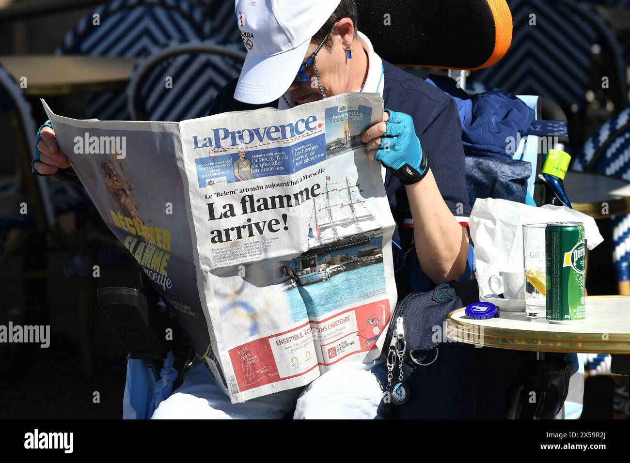 Marsiglia, Francia. 8 maggio 2024. Un residente legge un pezzo di giornale prima dell'arrivo della fiamma olimpica nel vecchio porto di Marsiglia, Francia meridionale, 8 maggio 2024. Crediti: Julien Mattia/Xinhua/Alamy Live News Foto Stock