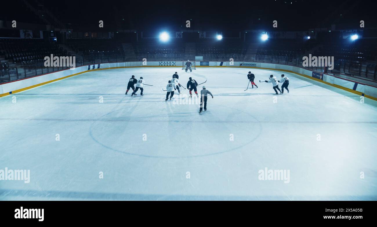 Ice Hockey Rink Arena: Fantastici attacchi di squadra, gioca con il pass usando tattiche e strategia creativa. Dribbling magistrali del giocatore. Un gioco fantastico e dinamico da parte della squadra. Scatto ad angolo alto Foto Stock