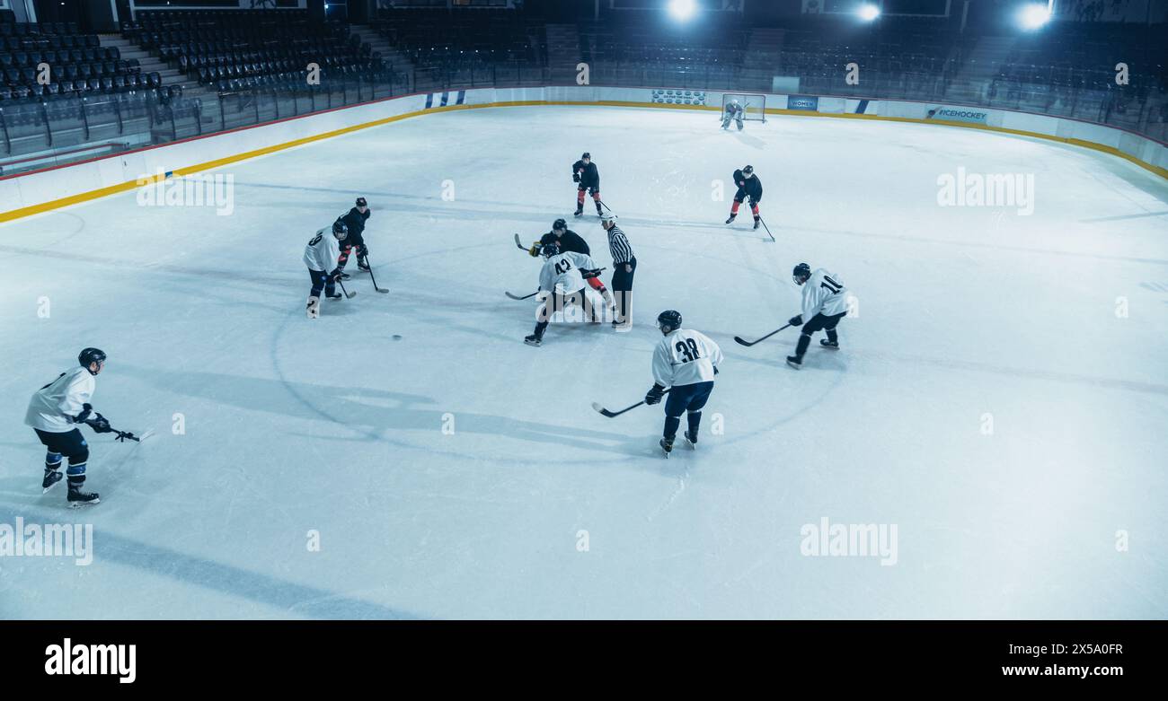 Ice Hockey Rink Arena: Fantastici attacchi di squadra, gioca con il pass usando tattiche e strategia creativa. Dribbling magistrali del giocatore. Un gioco fantastico e dinamico da parte della squadra. Scatto ad angolo alto Foto Stock
