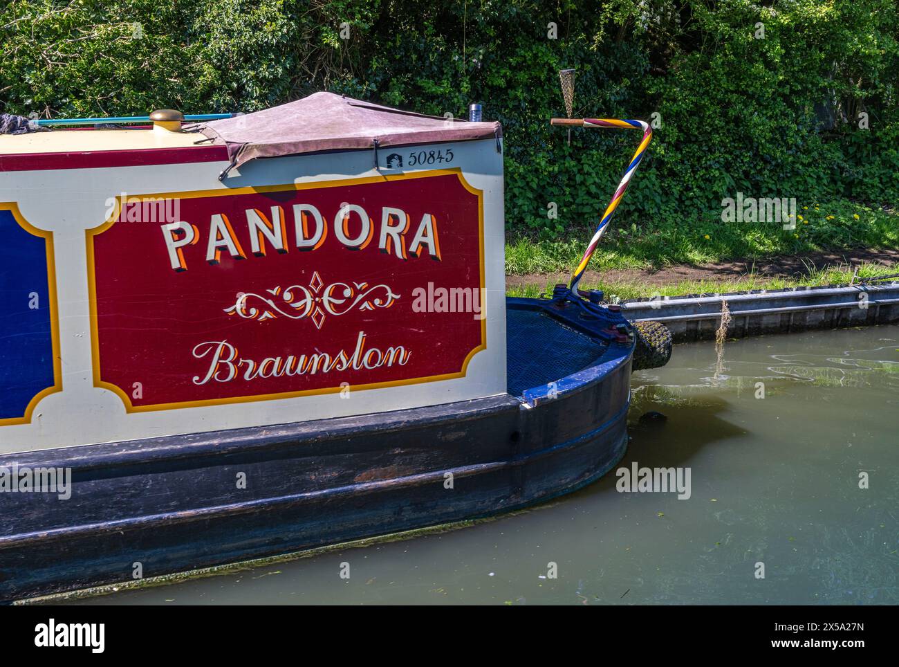 Oxford Canal, vicino a Rugby, Inghilterra, Regno Unito - Una barca stretta su un canale chiamato Pandora ormeggiata contro il sentiero della città Foto Stock