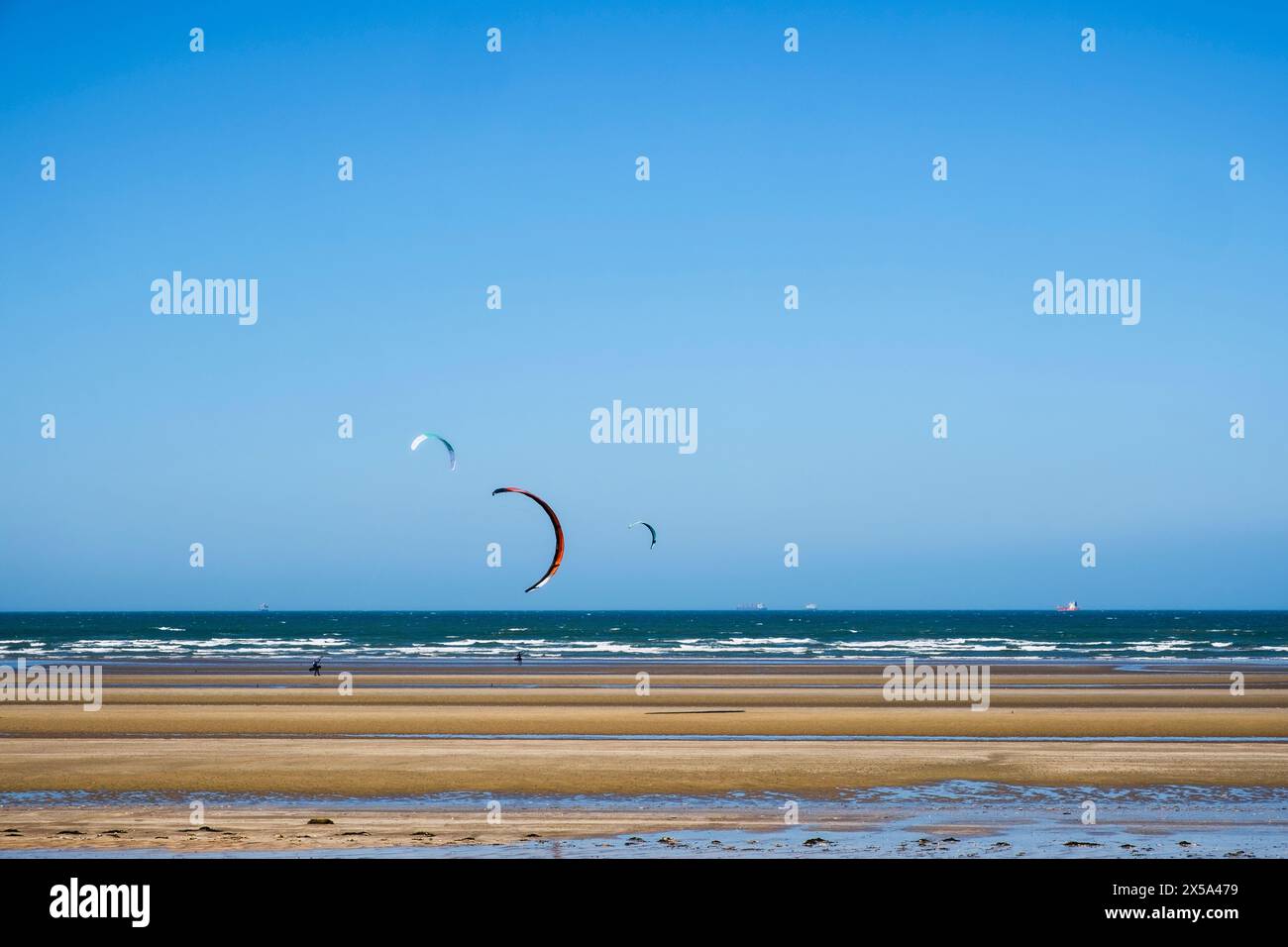 People Kite surf sulla spiaggia di Llanddona a Red Wharf Bay, Isola di Anglesey, Galles del nord, Regno Unito, Gran Bretagna Foto Stock