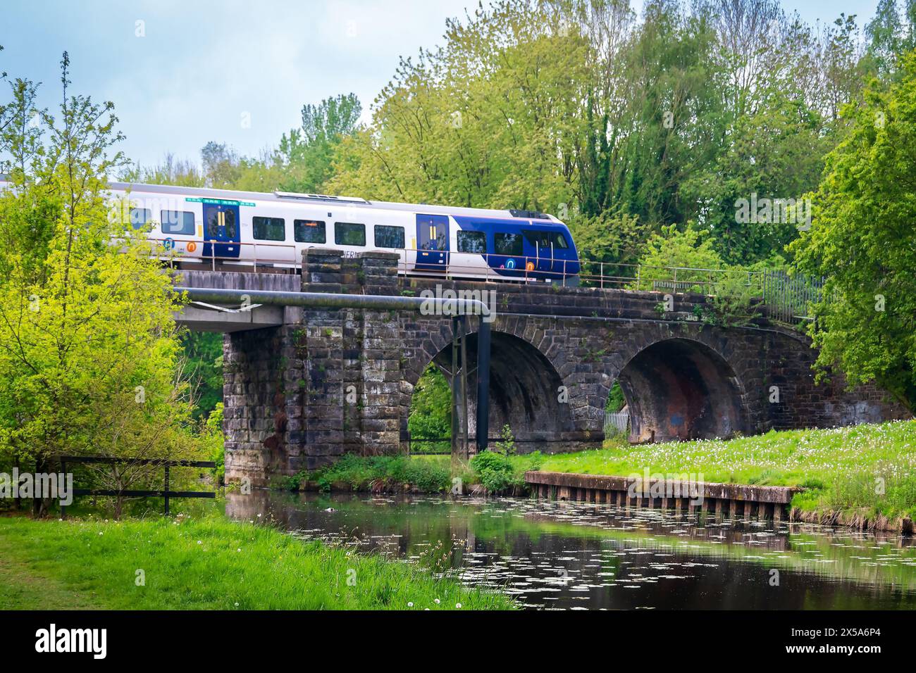 Parco di Sankey Valley con il canale di St Helens attraversato da un treno della Northern Rail a Warrington. Foto Stock