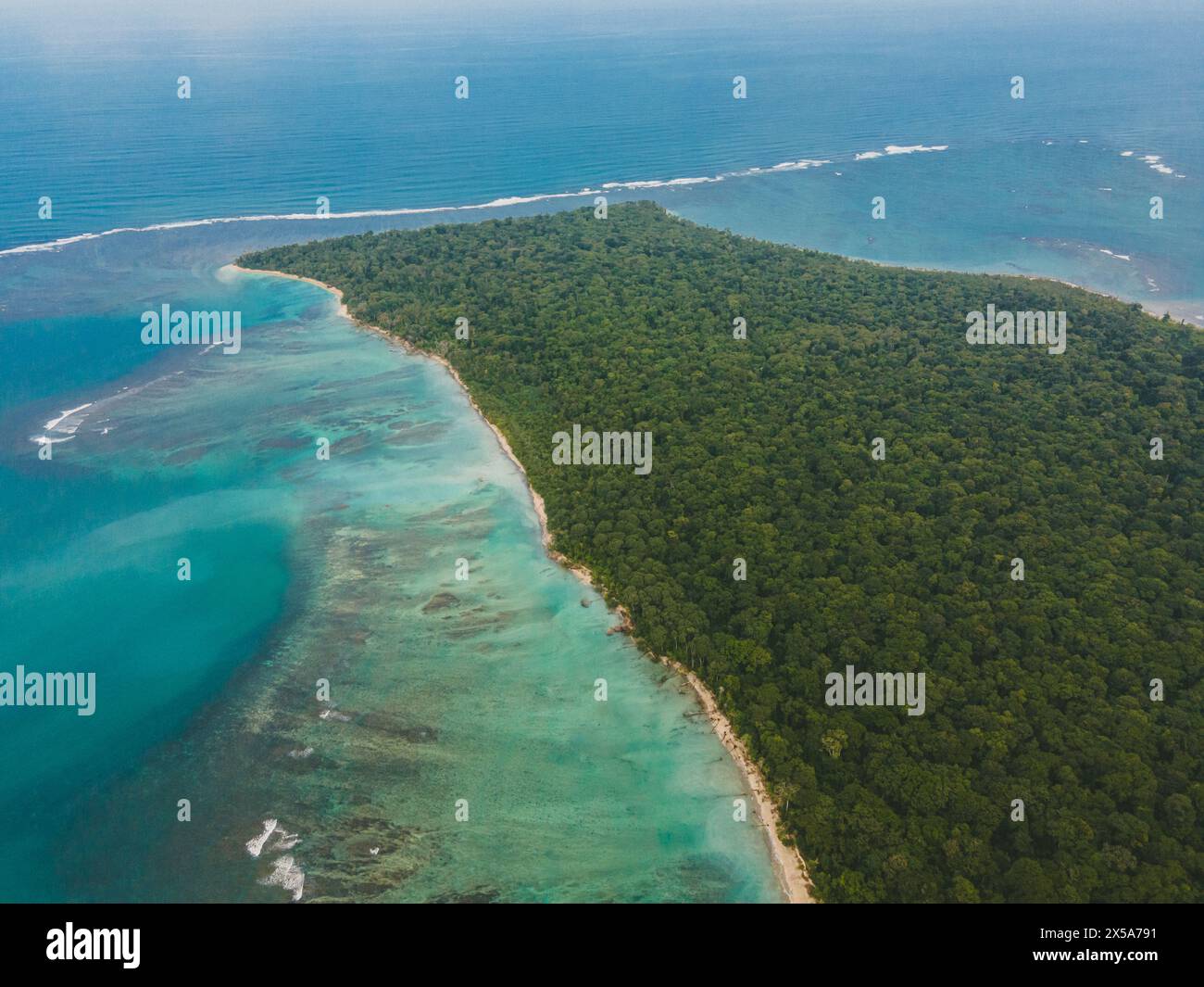 Uno scatto aereo cattura la splendida costa lussureggiante della Costa Rica con acque turchesi cristalline che incontrano la fitta foresta tropicale Foto Stock
