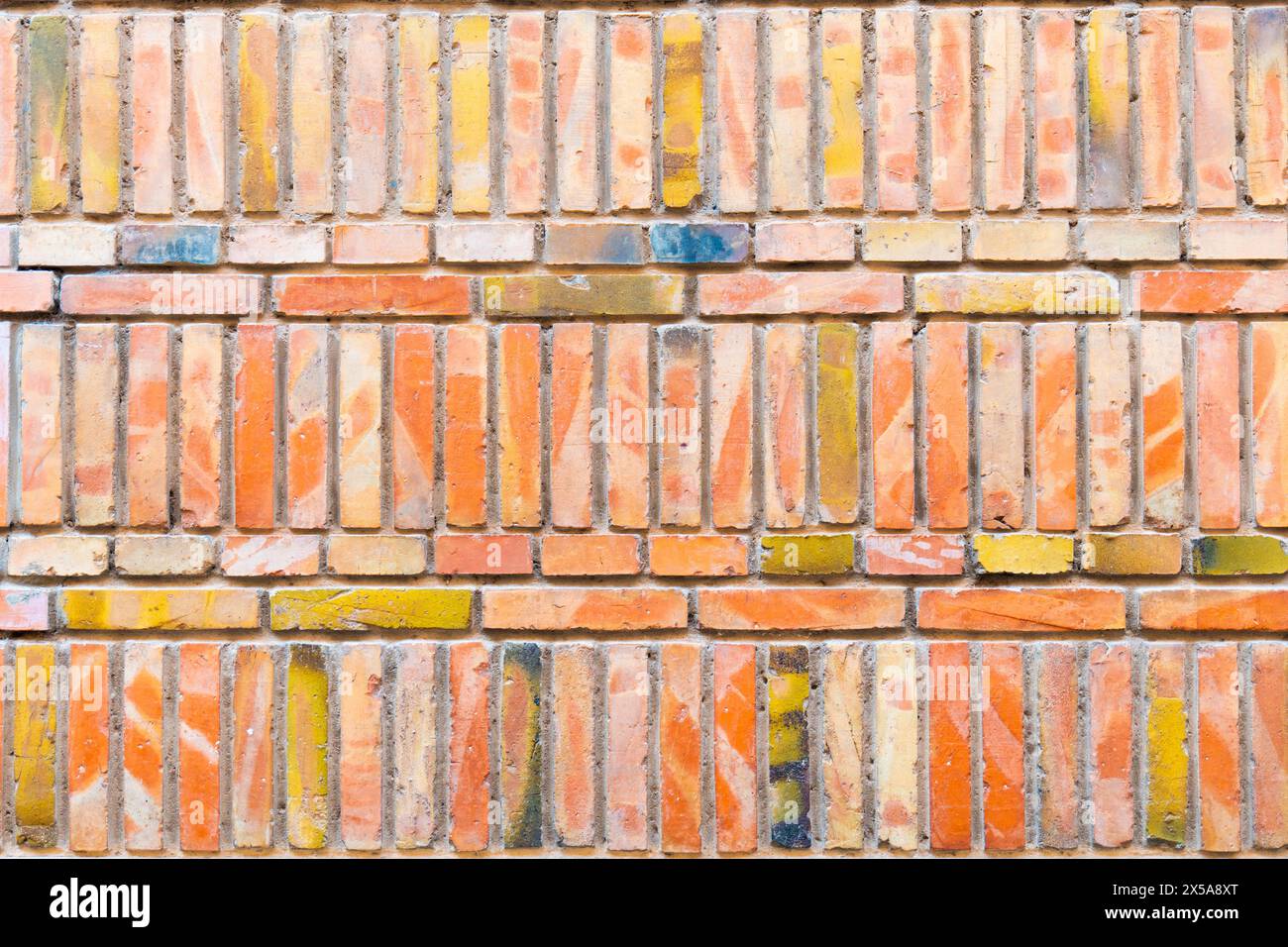 Immagine ad alta risoluzione che mostra una parete in mattoni testurizzati con una varietà di colori, adatta per sfondi ed elementi di design. Foto Stock