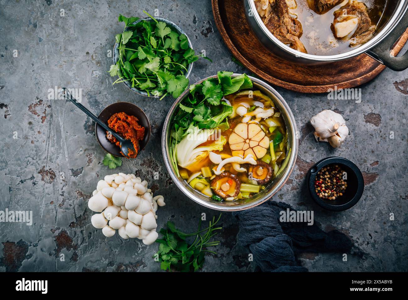 Brodo vegetale fatto in casa con brodo di manzo in pentole con ingredienti Foto Stock