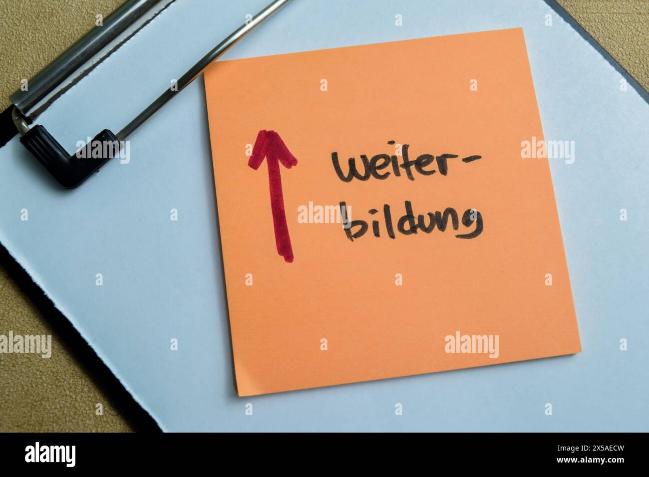 Concetto di Weiter Bildung scrivere su appiccicose note isolate su un tavolo di legno. Foto Stock