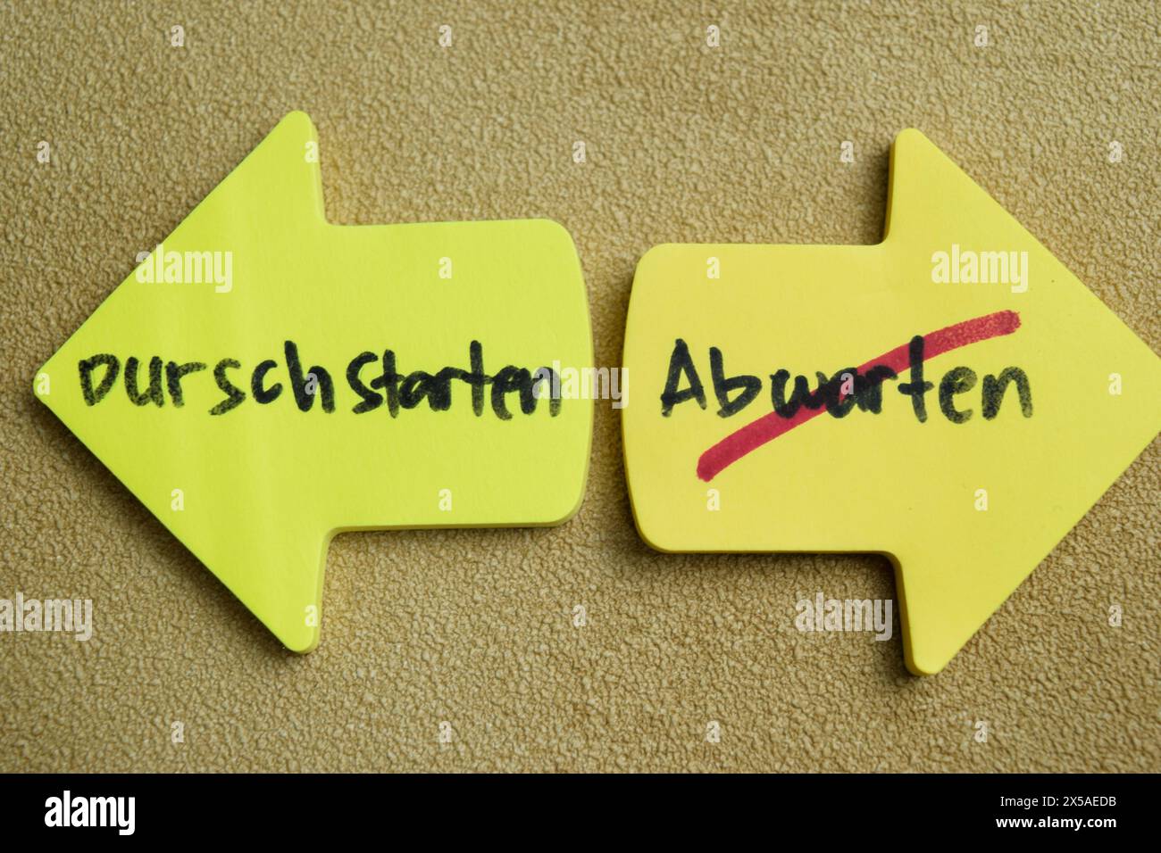 Concetto di Durschstarten o Abwarten scrivere su appiccicose note isolate su un tavolo di legno. Foto Stock