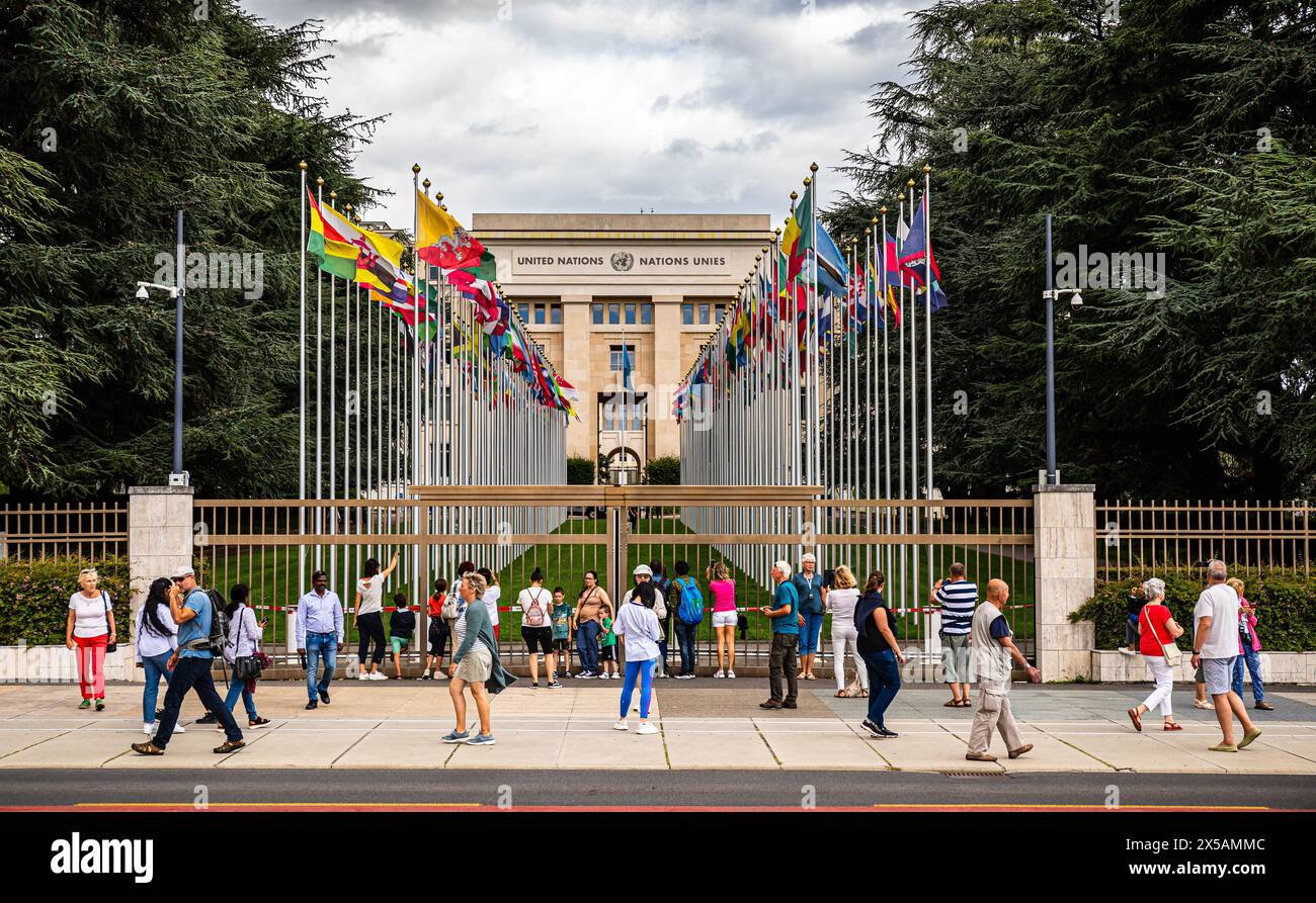 Blick auf den Palais des Nations, welches der Hauptsitz der Vereinten Nationen in Genf ist. Vorne am Sicherheitszaun sind zahlreichen Touristen zu fin Foto Stock