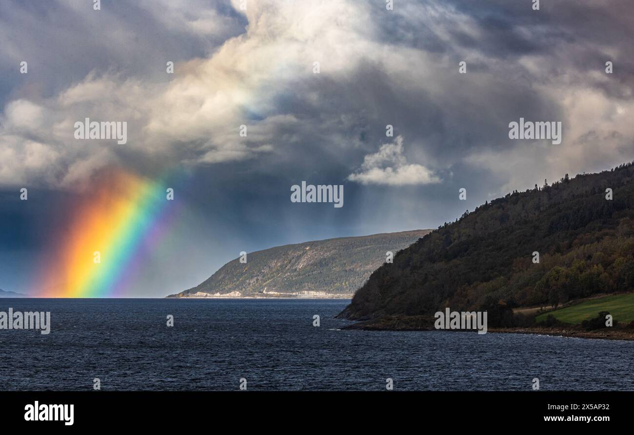 Dank Niederschlag in der Ferne und dem Einfall des Sonnenlichts konnte sich an der norwegischen Küsten in der Region Trondelag ein kräftiger Regenboge Foto Stock
