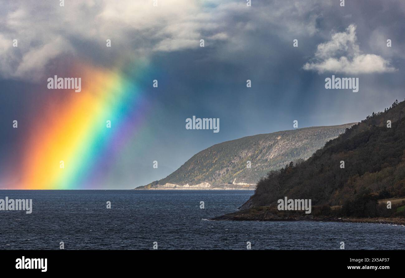 Dank Niederschlag in der Ferne und dem Einfall des Sonnenlichts konnte sich an der norwegischen Küsten in der Region Trondelag ein kräftiger Regenboge Foto Stock