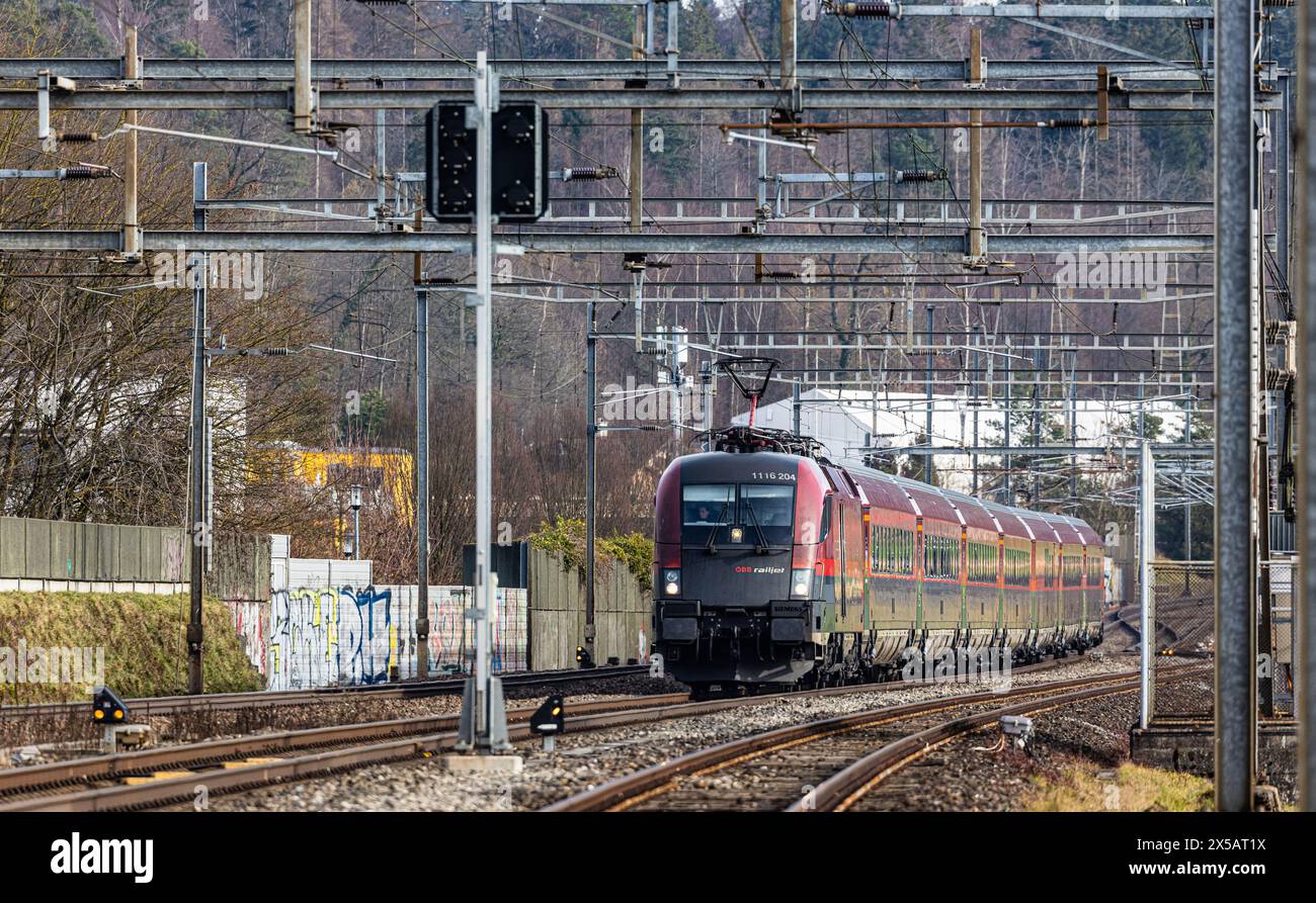 Der ÖBB Railjet ist aus Wien unterwegs an den Hauptbahnhof Zürich. Gezogen wird der Personenzug von einer Taurus Lokomotive. Der Zug fährt beim Bahnho Foto Stock