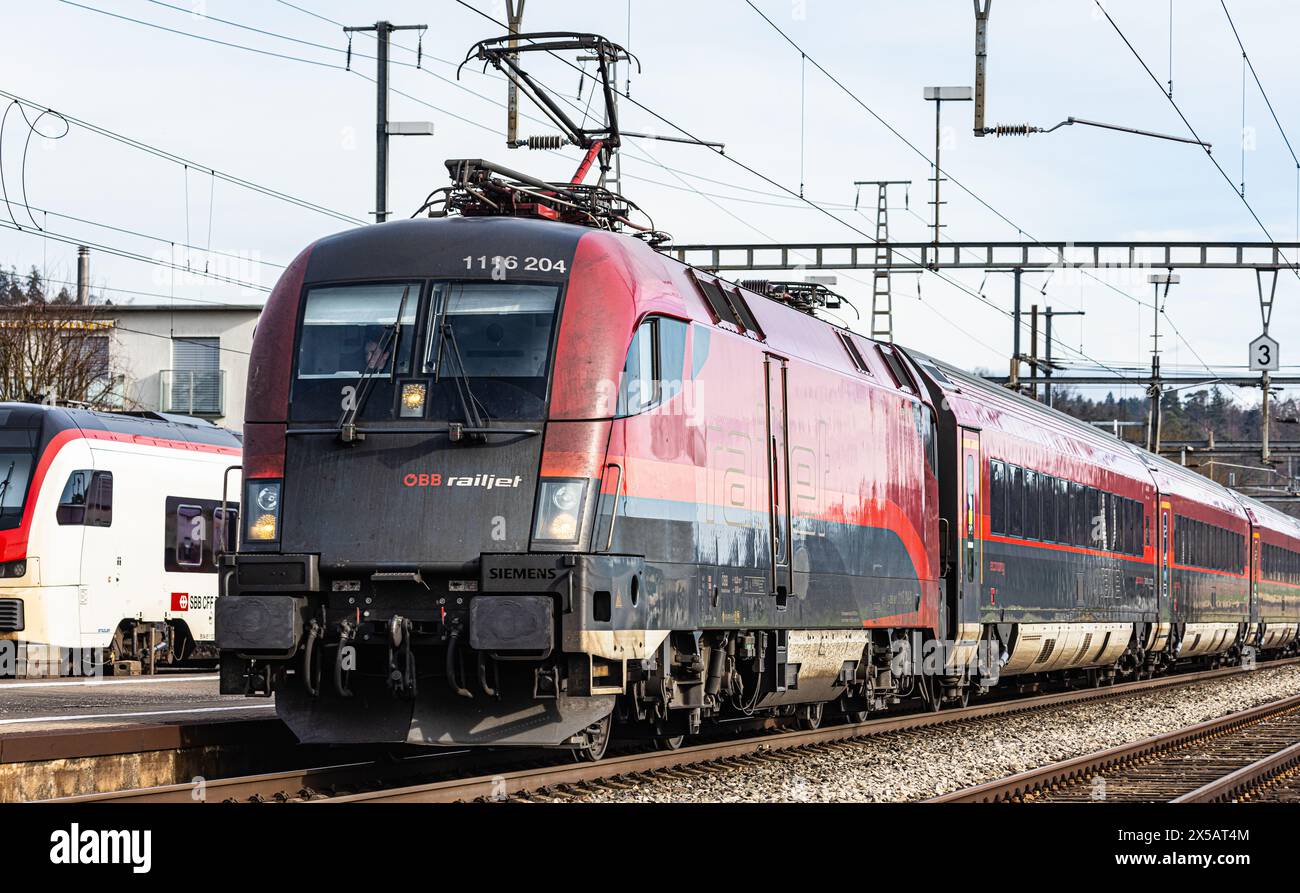 Der ÖBB Railjet ist aus Wien unterwegs an den Hauptbahnhof Zürich. Gezogen wird der Personenzug von einer Taurus Lokomotive. Der Zug fährt beim Bahnho Foto Stock