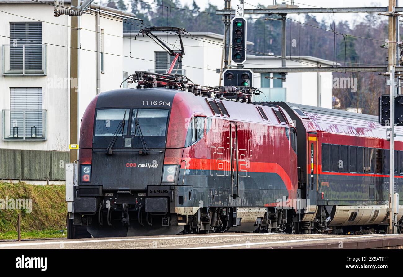 Der ÖBB Railjet ist aus Wien unterwegs an den Hauptbahnhof Zürich. Gezogen wird der Personenzug von einer Taurus Lokomotive. Der Zug fährt beim Bahnho Foto Stock