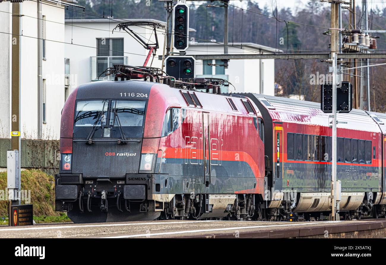 Der ÖBB Railjet ist aus Wien unterwegs an den Hauptbahnhof Zürich. Gezogen wird der Personenzug von einer Taurus Lokomotive. Der Zug fährt beim Bahnho Foto Stock