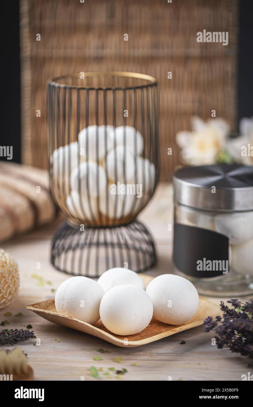Serena sistemazione spa con bombe da bagno bianche, fiori aromatici ed essenziale per il bagno Foto Stock