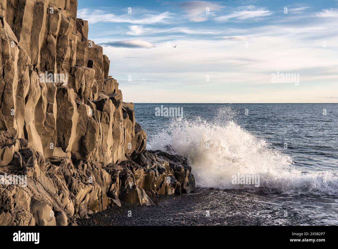 Vista panoramica delle onde che colpiscono la grotta di Halsanefhellir con formazione rocciosa di basalto sulla spiaggia di sabbia nera di Reynisfjara a Vik, Islanda Foto Stock