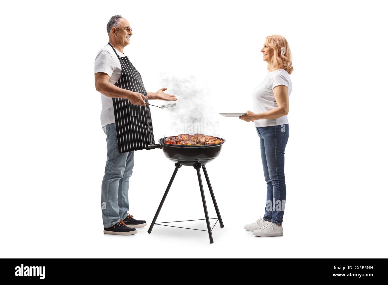 Uomo che grigia carne su un barbecue e parla con una donna isolata su sfondo bianco Foto Stock