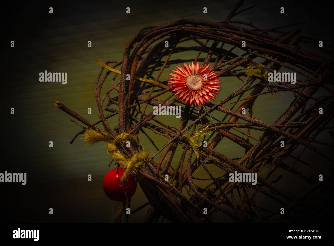 Primo piano di una parte del cuore fatta di salice e fiore rosso brillante Foto Stock