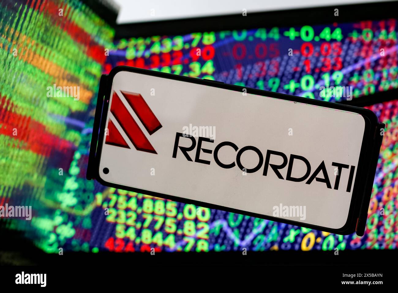 Cracovia, Polonia. 8 maggio 2024. In questa immagine, il logo Recordati industria chimica e farmaceutica Spa è visualizzato sullo schermo di uno smartphone contro uno schermo di un computer e i suoi riflessi mostrano un'illustrazione dei numeri del mercato azionario è che l'azienda rilascia il suo guadagno Q1- Cracovia, Polonia, l'8 maggio 2024. (Foto di Dominika Zarzycka/Sipa USA) credito: SIPA USA/Alamy Live News Foto Stock