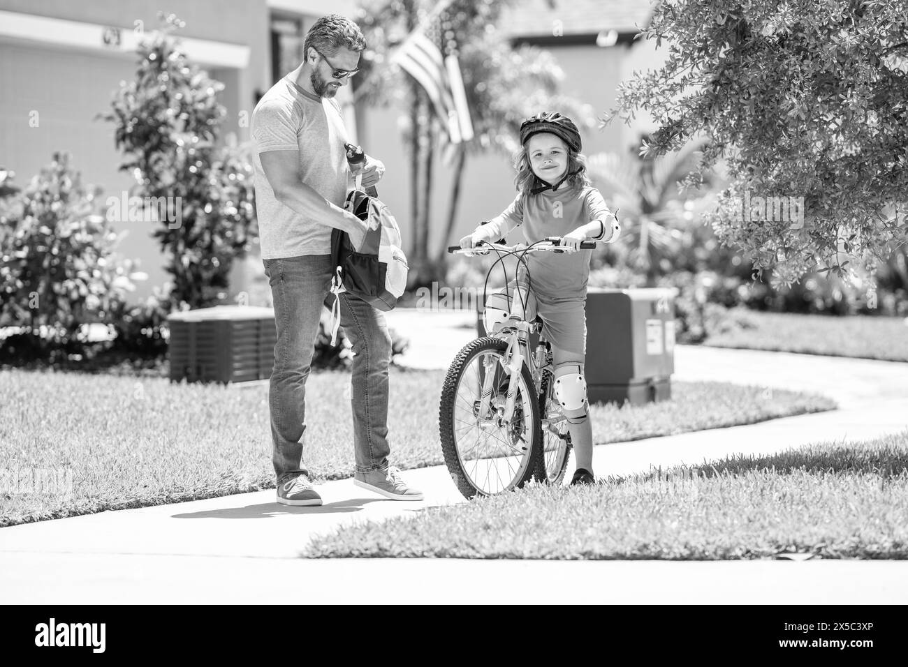 padre e figlio all'aperto. padre e figlio si divertono in bicicletta insieme. esperienza di incollaggio su due ruote. due figli e papà attivi in bicicletta Foto Stock