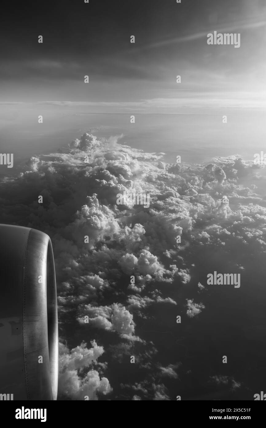 Vista dalla finestra di un aereo che vola sopra le nuvole, foto in bianco e nero. Foto Stock