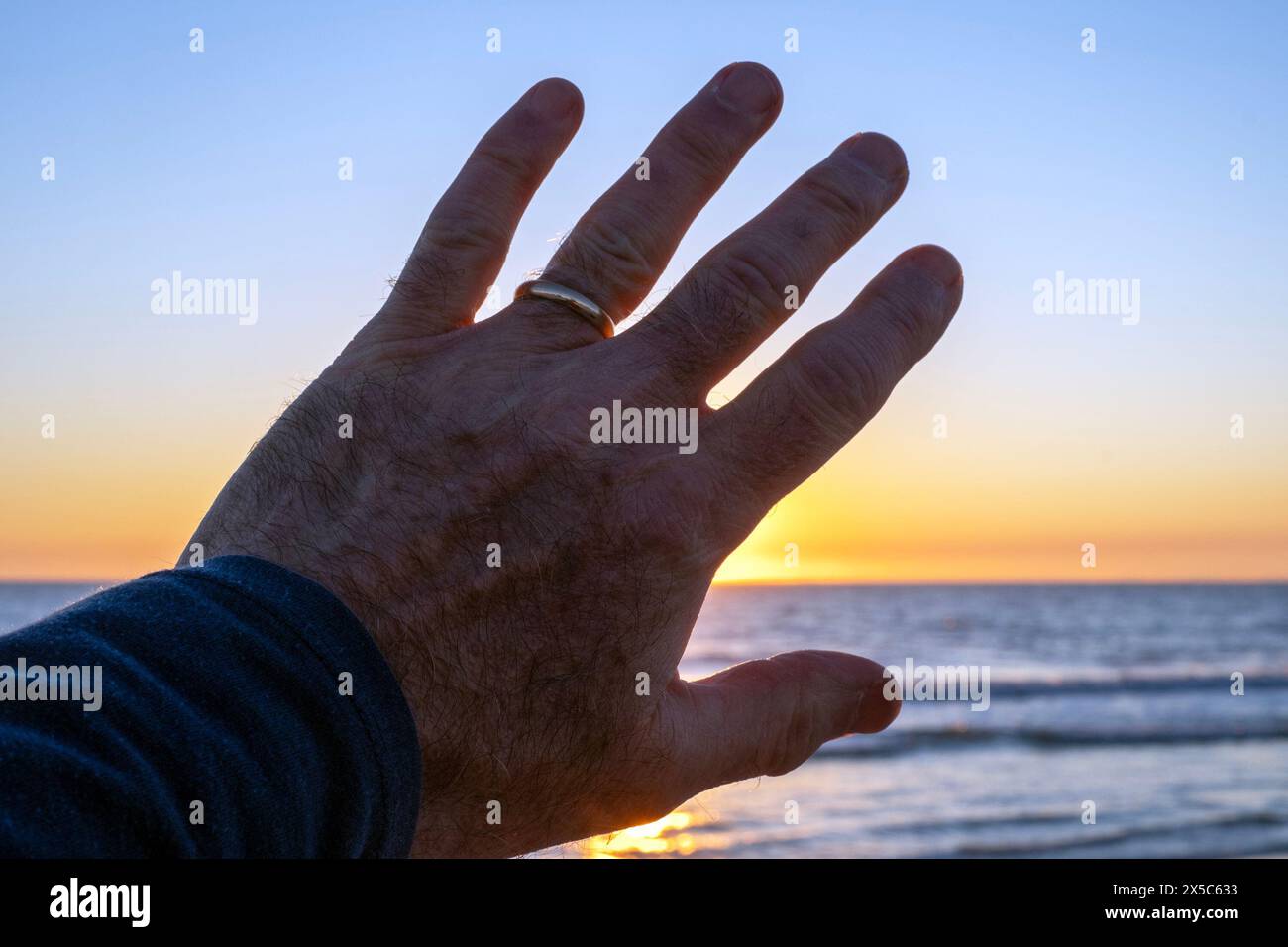 Il sole è bloccato da una mano. Foto Stock