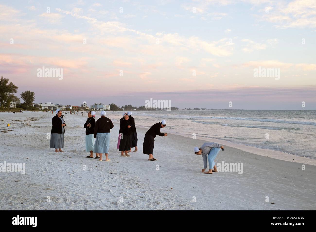 Un gruppo di donne mennonite trascorre del tempo sulla spiaggia di Anna Maria Island, Florida, Stati Uniti. Foto Stock