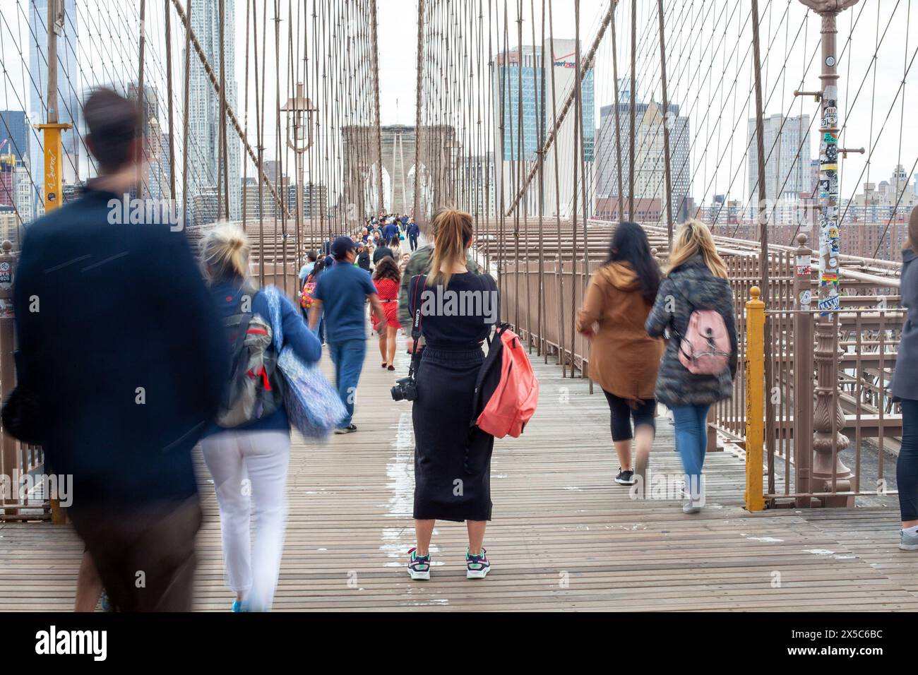 Una fotografa detiene la sua posizione sul ponte di Brooklyn a New York City, Stati Uniti. Foto Stock