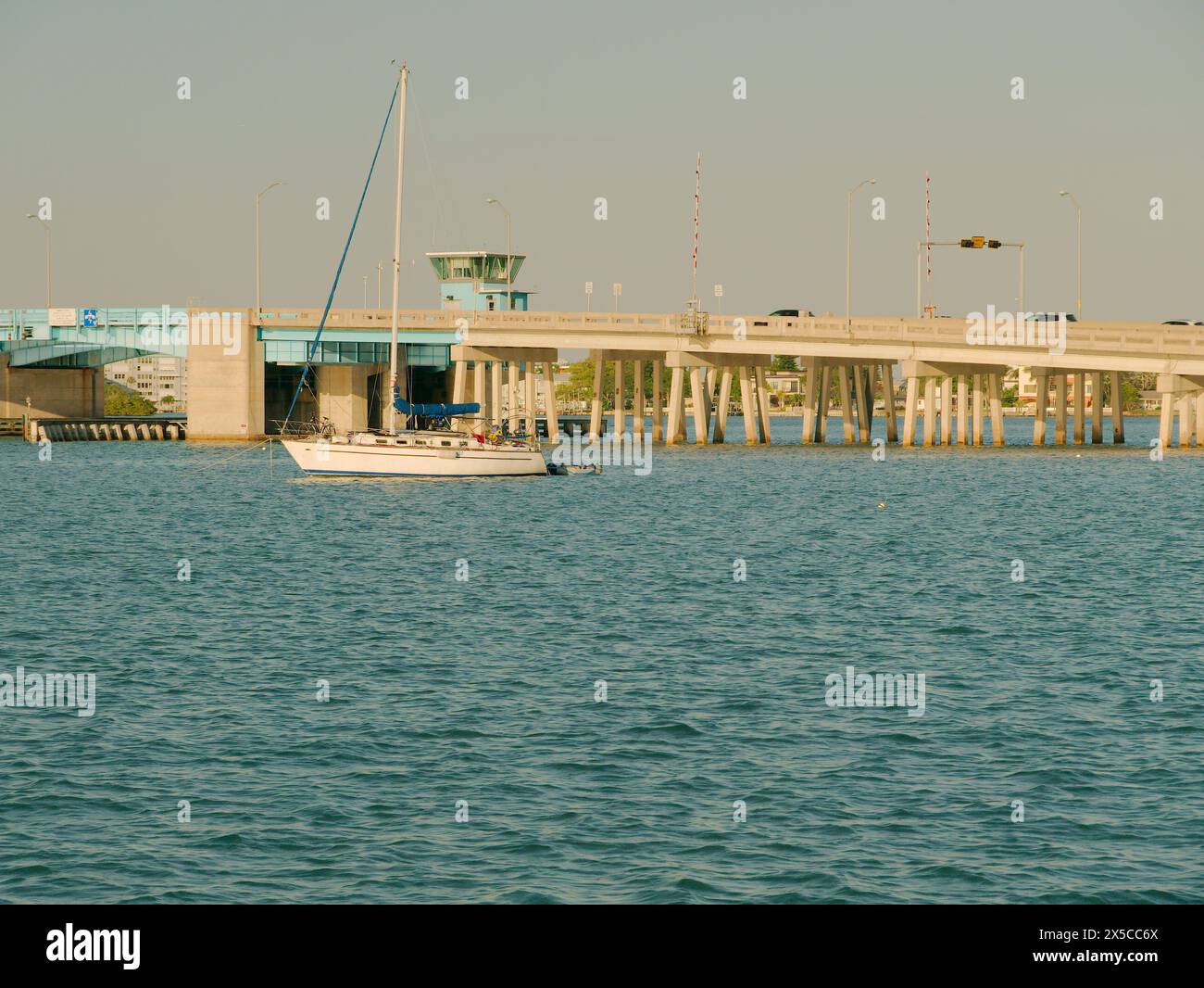 Ampia vista sud-est dal St Pete Beach Community Center verso il ponte levatoio Corey Causeway Boca Ciega Bay con barca a vela senza albero al tramonto in acque blu Foto Stock