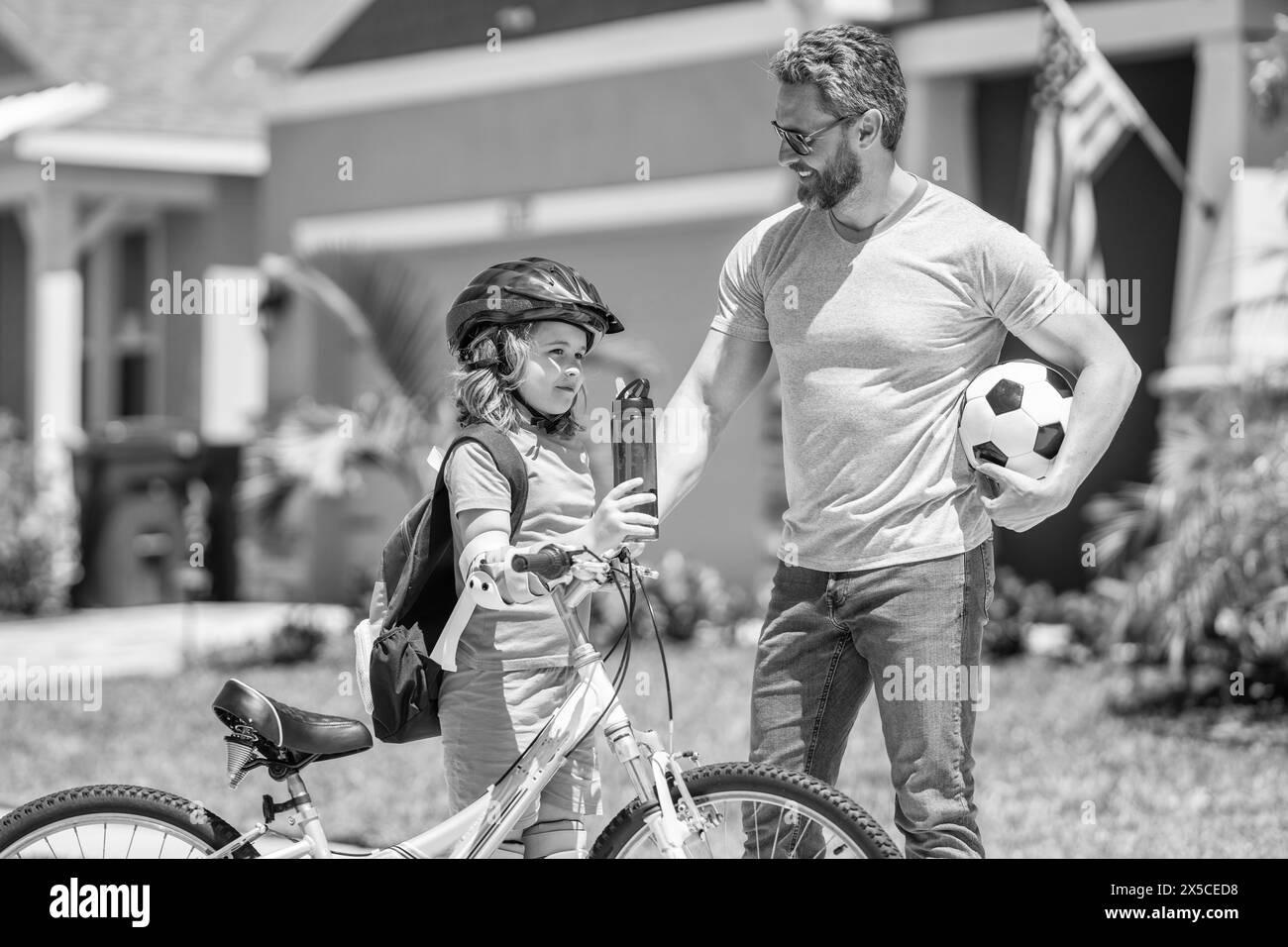 papa' e figlio che sviluppano la sua infanzia in bicicletta all'aperto insieme Foto Stock