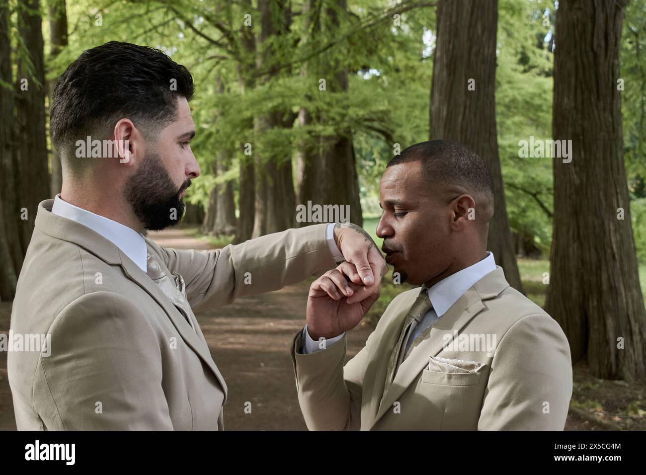 Un uomo che bacia la mano di un altro uomo, orgoglio gay di diversità Foto Stock