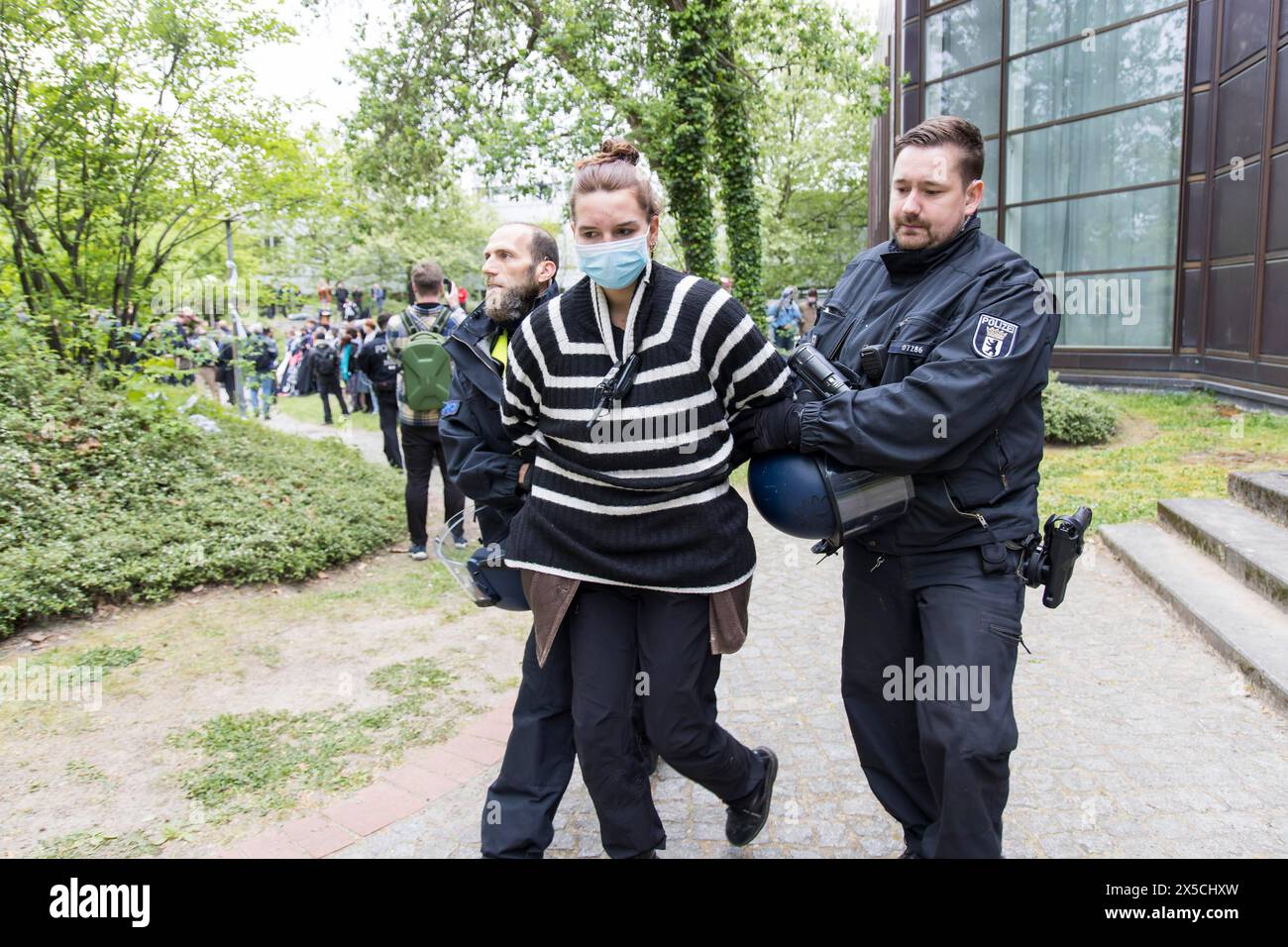 Un attivista viene portato via dalla polizia durante l'occupazione del cortile della libera Università di Berlino da parte di attivisti filo-palestinesi. Alcuni di Foto Stock