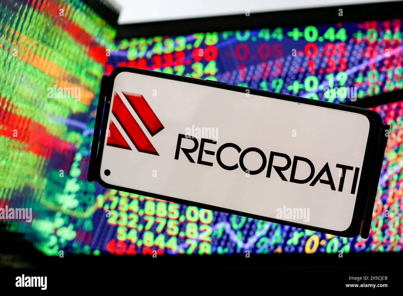 Cracovia, Polonia. 8 maggio 2024. In questa immagine, il logo Recordati industria chimica e farmaceutica Spa è visualizzato sullo schermo di uno smartphone contro uno schermo di un computer e i suoi riflessi mostrano un'illustrazione dei numeri di borsa sono l'azienda che rilascia i suoi guadagni Q1. (Foto di Dominika Zarzycka/SOPA Images/Sipa USA) *** esclusivamente a scopo editoriale *** credito: SIPA USA/Alamy Live News Foto Stock