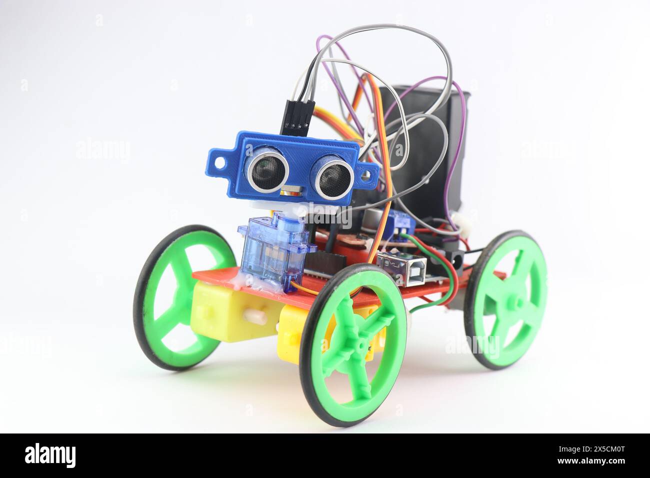 Auto robotizzata realizzata con parti stampate in 3D ed è programmabile e dotata di sensore a ultrasuoni per il rilevamento di ostacoli e altri componenti elettronici Foto Stock