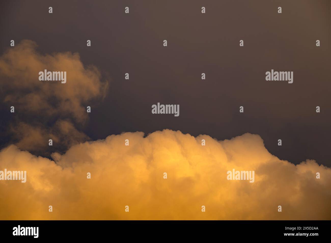 Grande nuvola gialla nel cielo al sole della sera Foto Stock