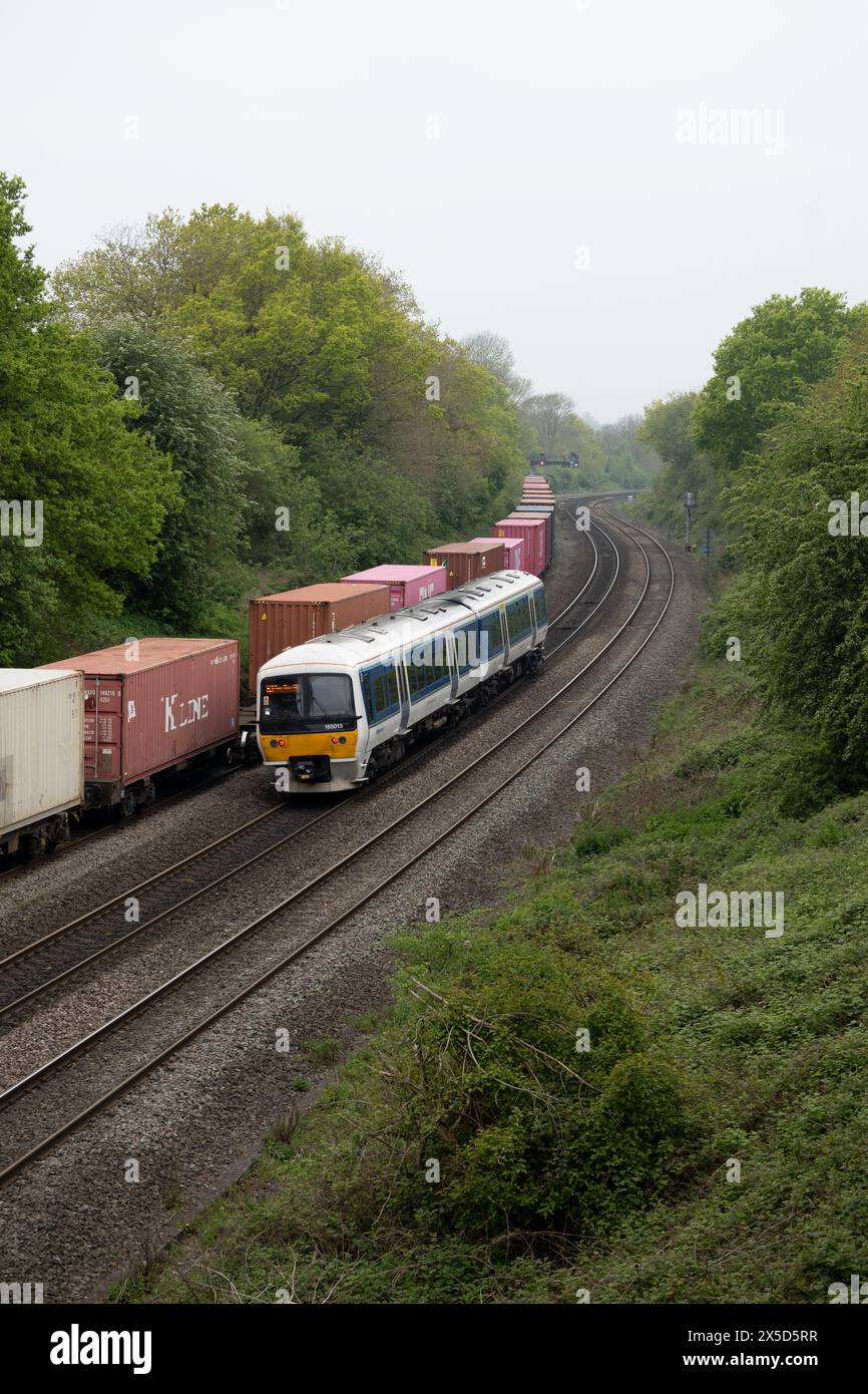 Chiltern Railways classe 165 diesel che passa un treno freightliner a Hatton Down Loop line, Warwickshire, Regno Unito Foto Stock