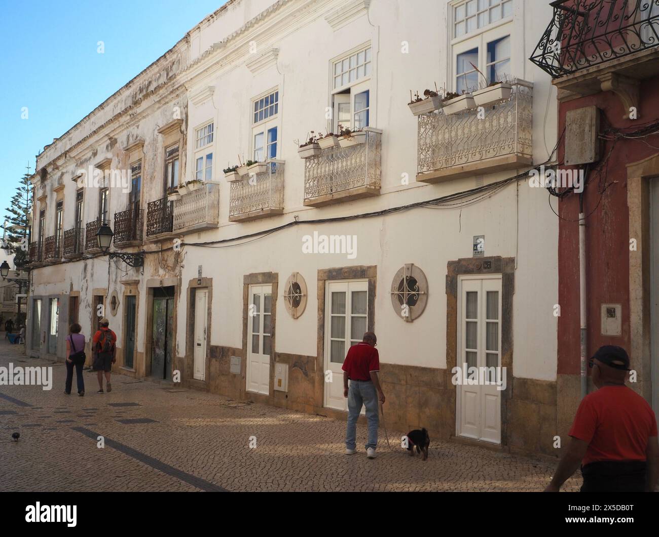Vecchie case in pietra portoghesi ben tenute con balconi Giulietta, con proprietà meno ben tenute sullo sfondo. Rua Vasco da Gama, Olhão, Algarve Portogallo Foto Stock