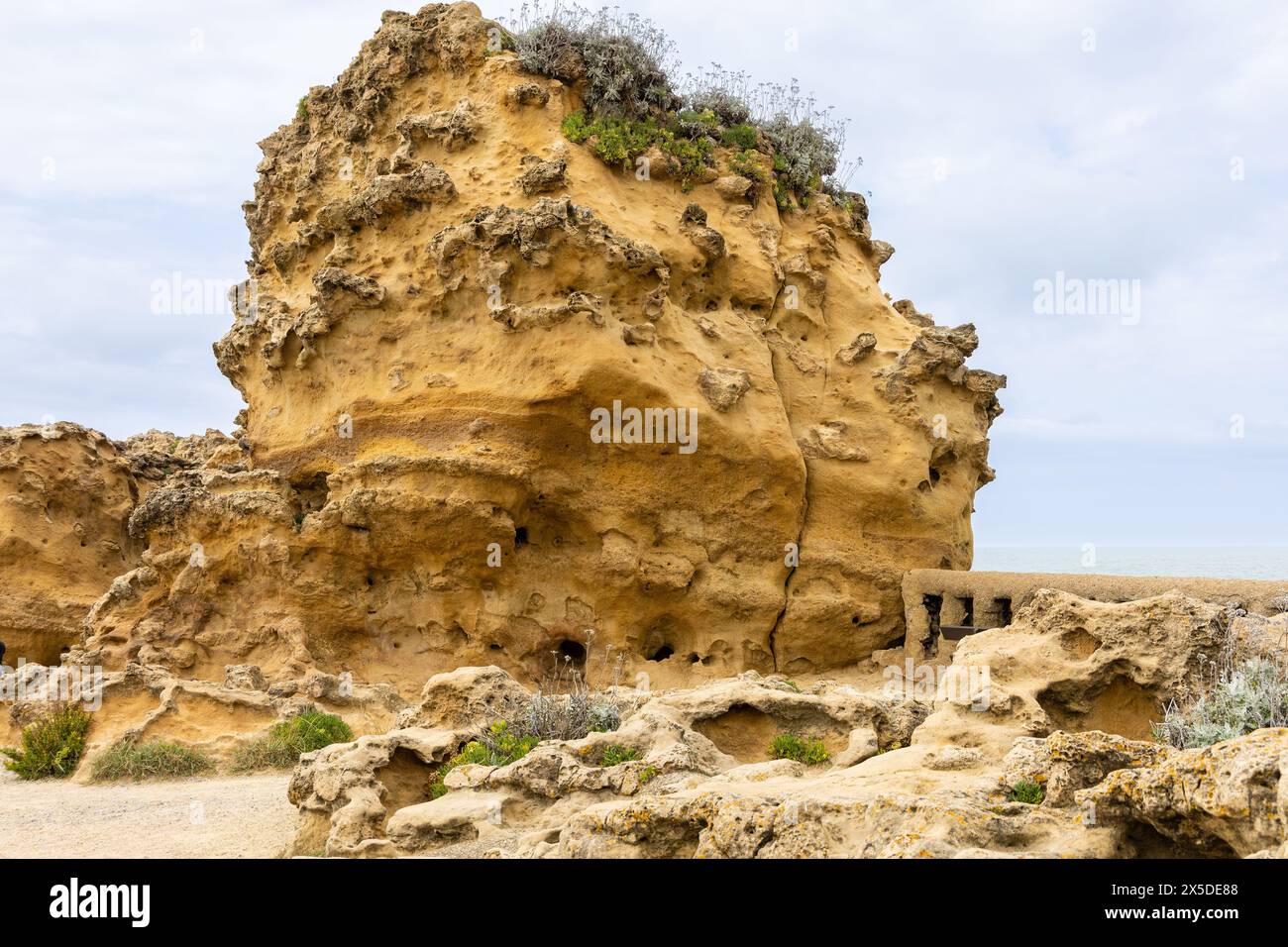 Un'insolita roccia gialla di forma interessante sul lungomare, vicino alla Rocca della Vergine (Rocher de la Vierge). Biarritz, Francia. Foto Stock