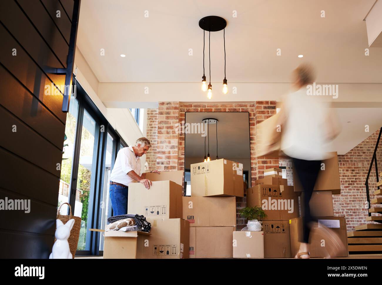 Coppia matura, traslochi e casse in casa, velocità e proprietà per immobili, affollati e disimballati. Mutuo, uomo e partner in matrimonio, proprietario di casa e.. Foto Stock