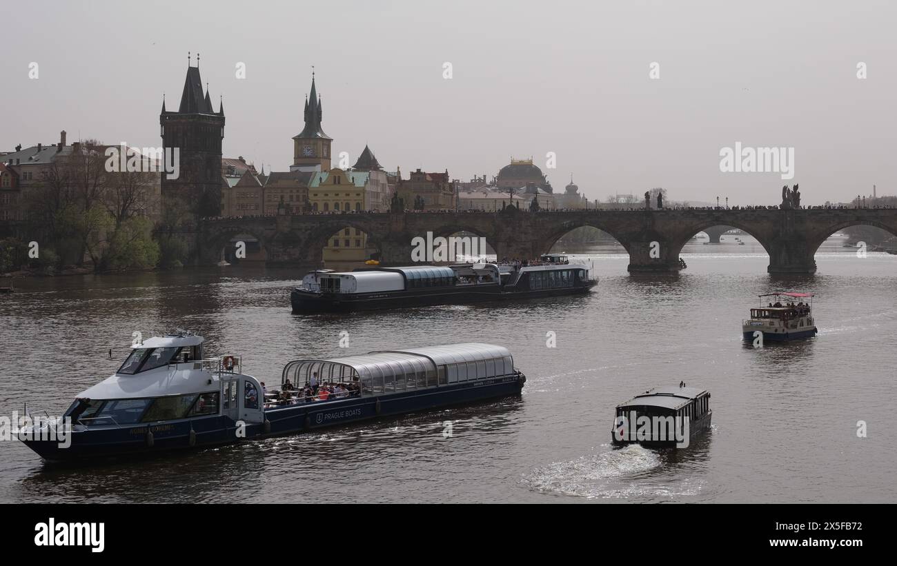 Praga, repubblica ceca - 3 marzo 2024: Tour in barca fluviale di fronte al ponte di Praga con i turisti visibili Foto Stock