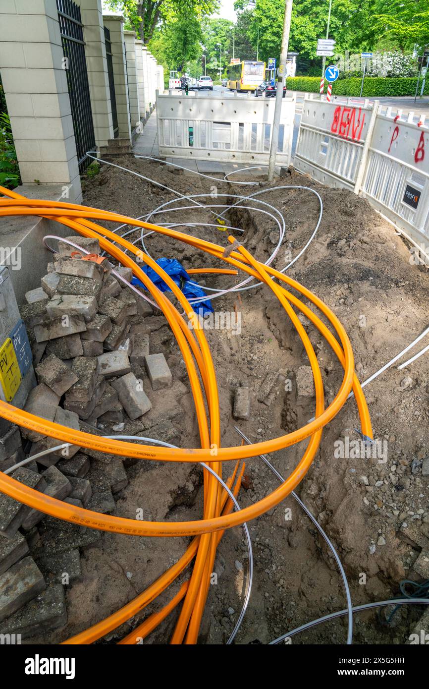 Posa di cavi in fibra ottica, i condotti vuoti sono posti sotto un marciapiede, in cui il cavo in fibra ottica effettivo viene successivamente soffiato e collegato alla r Foto Stock