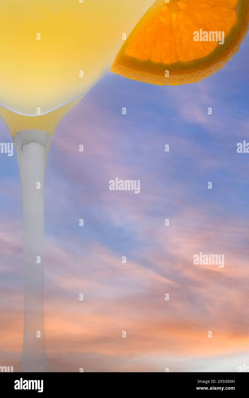 Cocktail estivo, fetta d'arancia contro uno splendido cielo estivo del tardo pomeriggio Foto Stock