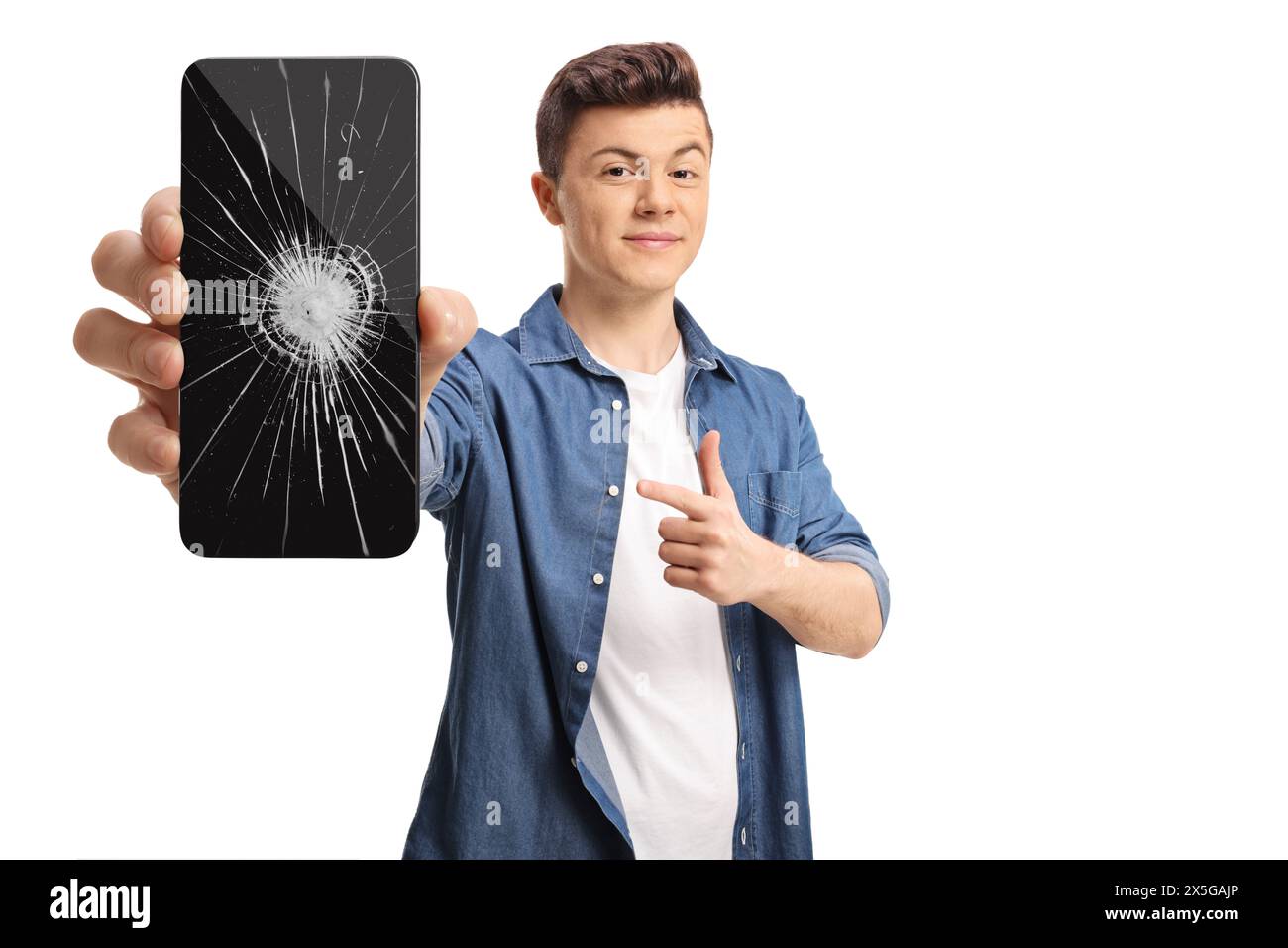 Adolescente maschio che tiene in mano uno smartphone e punta verso una crepa dello schermo isolata su sfondo bianco Foto Stock