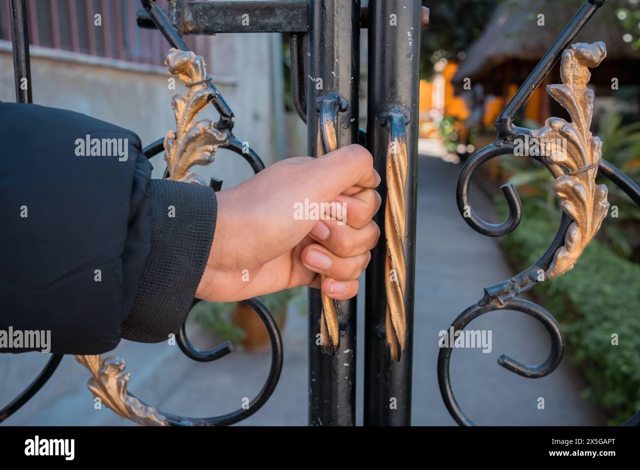 Mano di uomo che chiude il cancello. Foto Stock