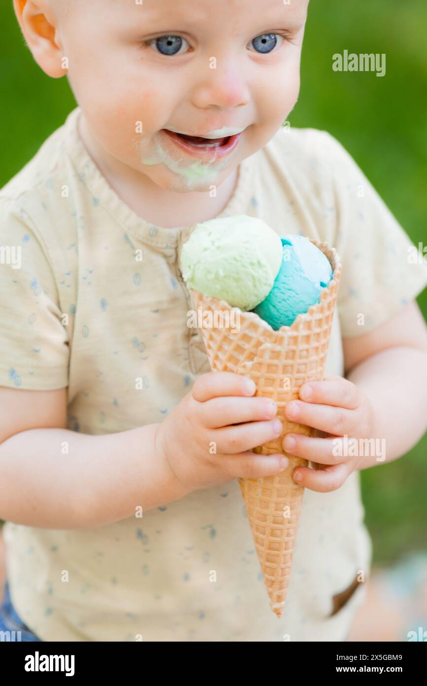 il bambino mangia il gelato nel parco in estate. Foto di alta qualità Foto Stock