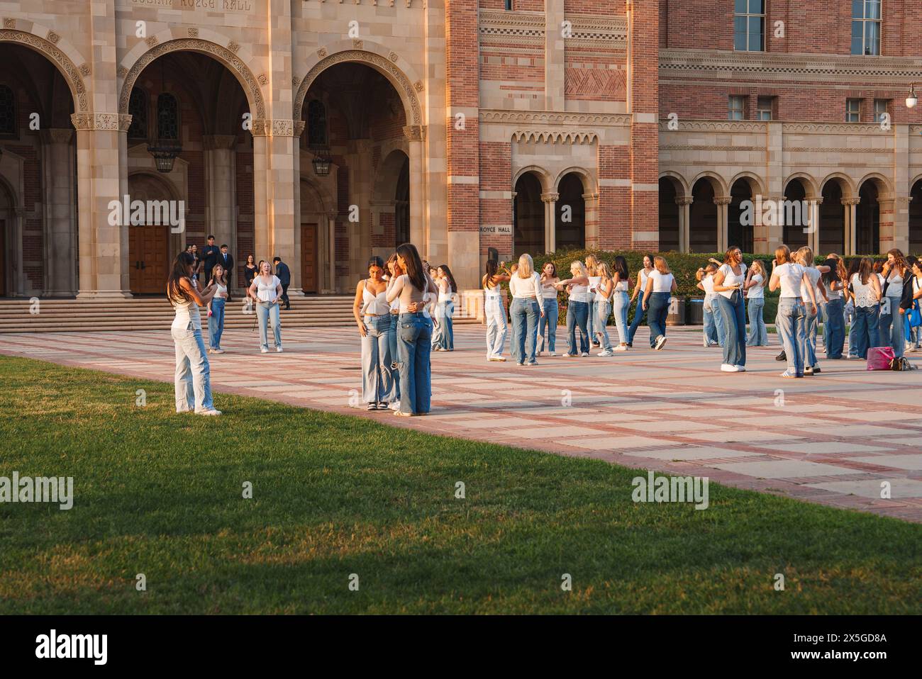 Persone che si riuniscono nel cortile storico di un grande edificio accademico Foto Stock