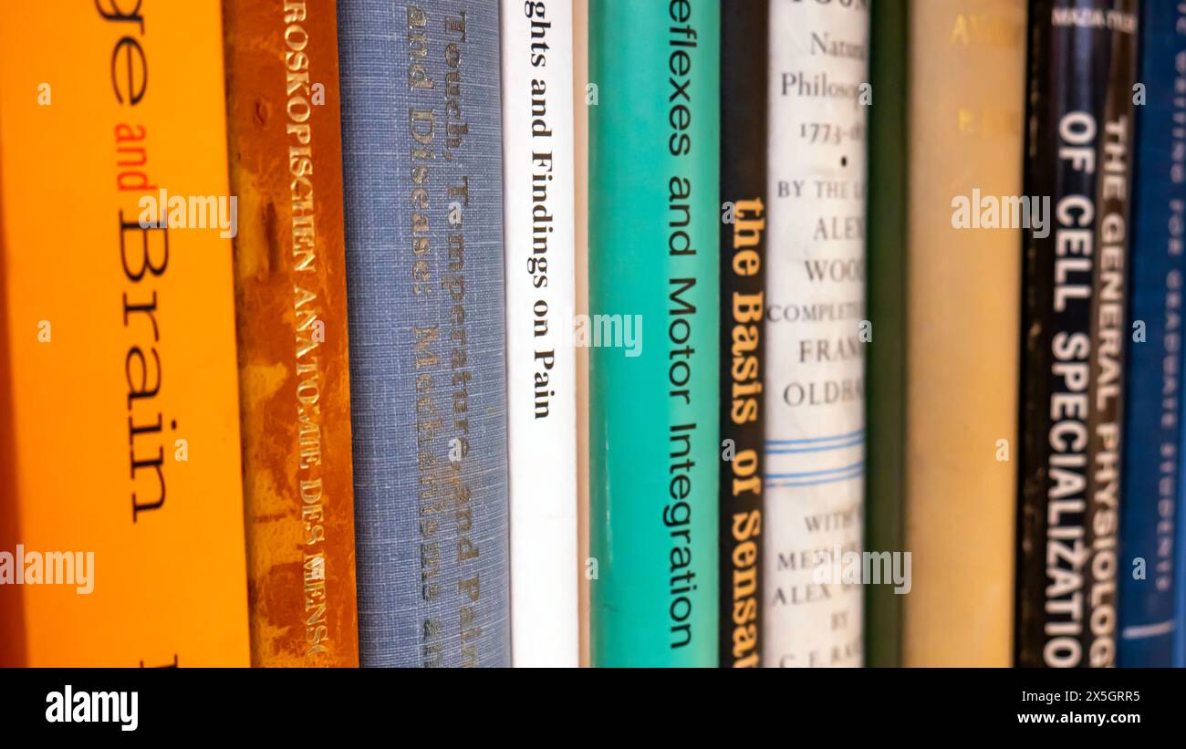 Una collezione di neuroscienze, biologia cellulare e libri di testo medici su uno scaffale nella biblioteca di una scuola di medicina o di un'università di ricerca Foto Stock