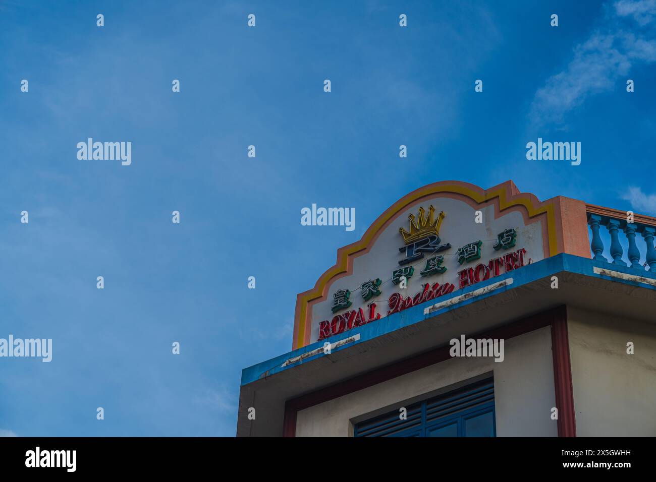 Immagine vivida della segnaletica del Royal Garden Hotel montata su una facciata di un edificio, evidenziata su un cielo blu limpido con soffici nuvole bianche. Foto Stock